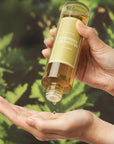 showcase of a hand using mugwort essence on leaf background