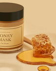picture of i'm from honey mask with wooden spoon holding honey comb and honey next to it on a yellow background