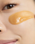woman applying i'm from honey mask on face