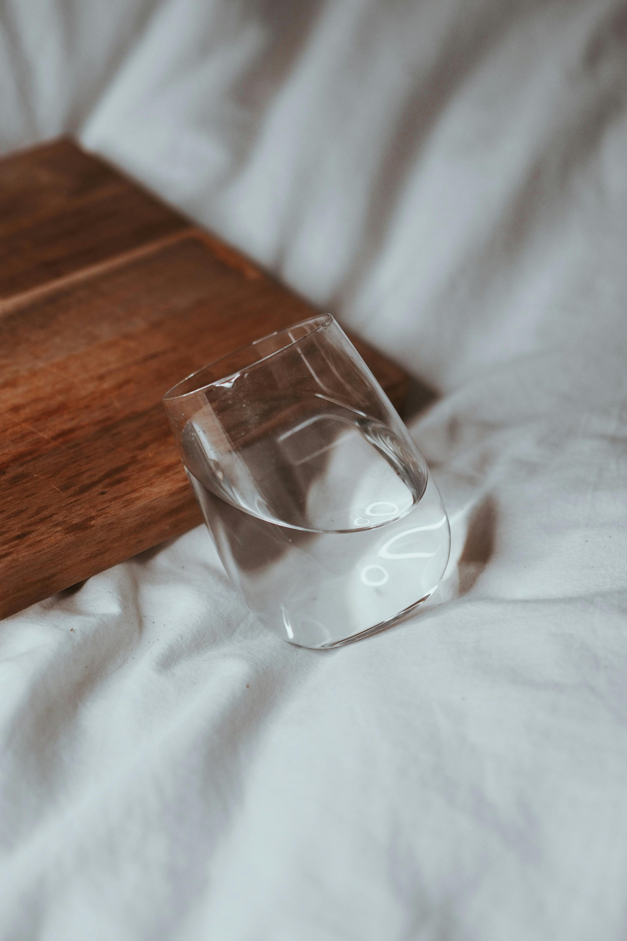 Water Cup On Bed leaning on wood 